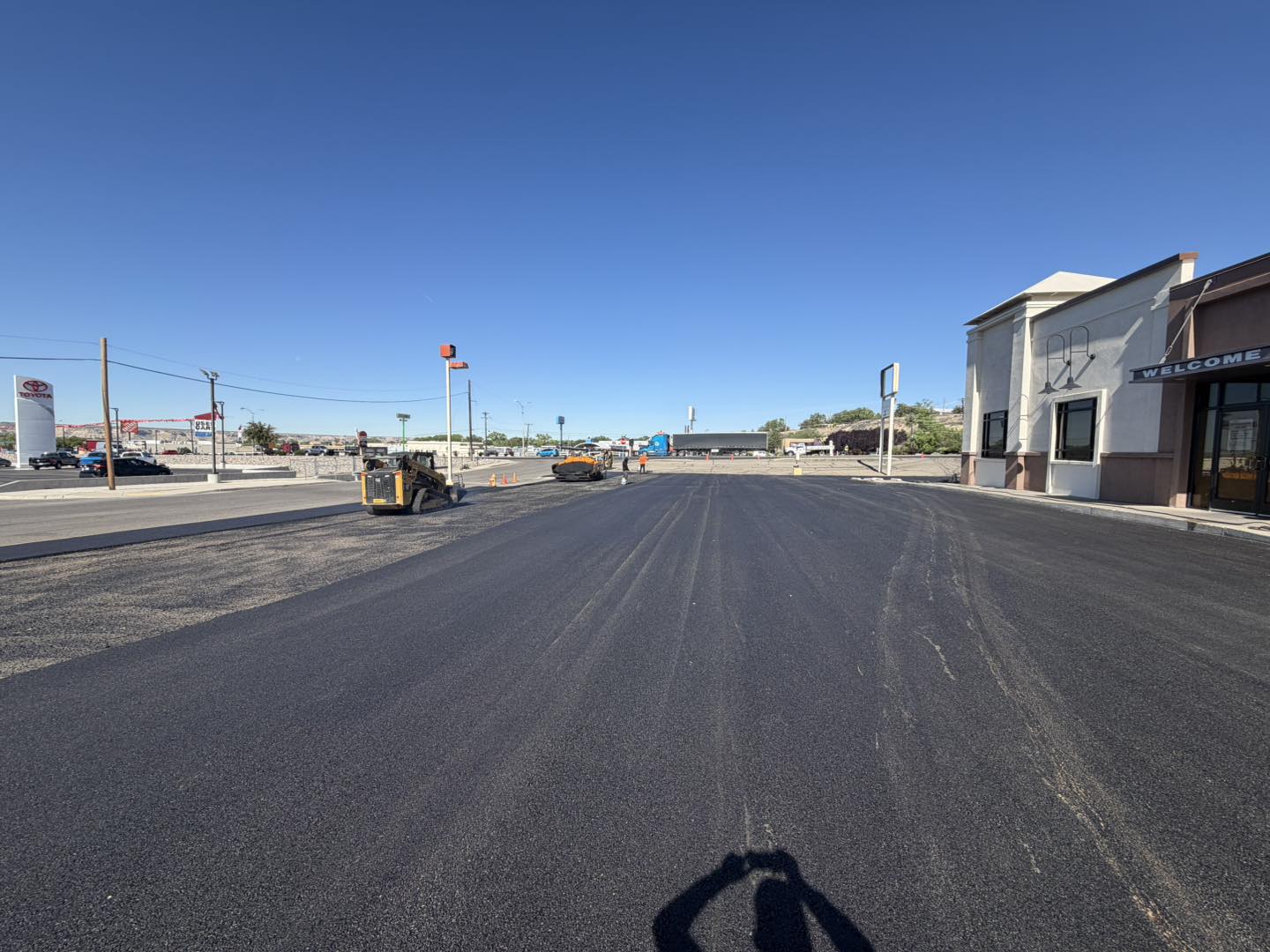 Freshly paved auto dealer parking lot with mountain views
