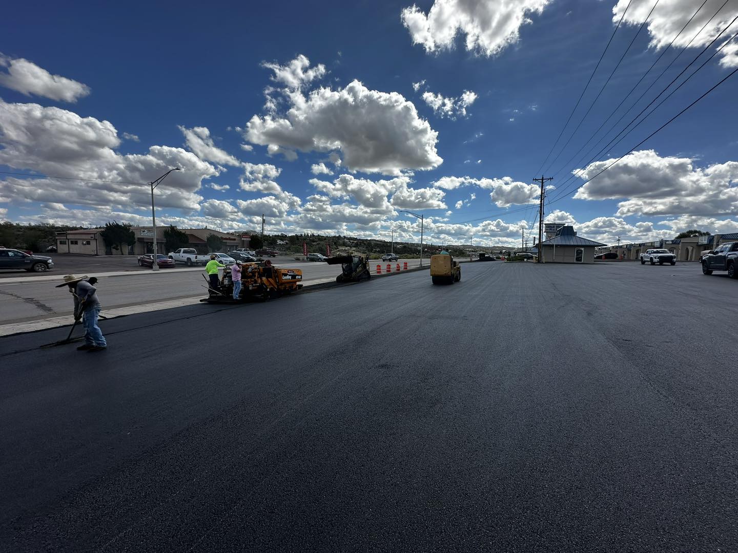 Paver and roller laying fresh asphalt on a New Mexico street